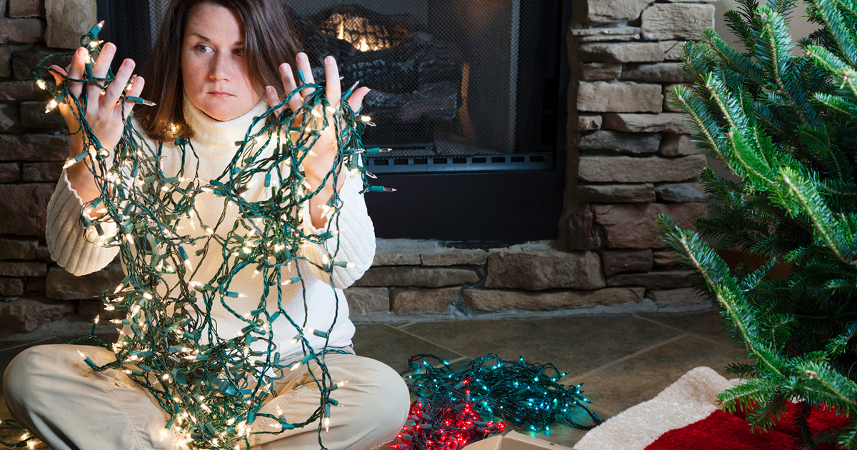 Woman holding tangled Christmas lights.