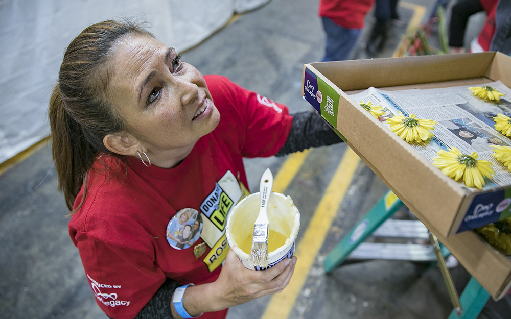 Holly Miyagawa holding paint and paint brush.