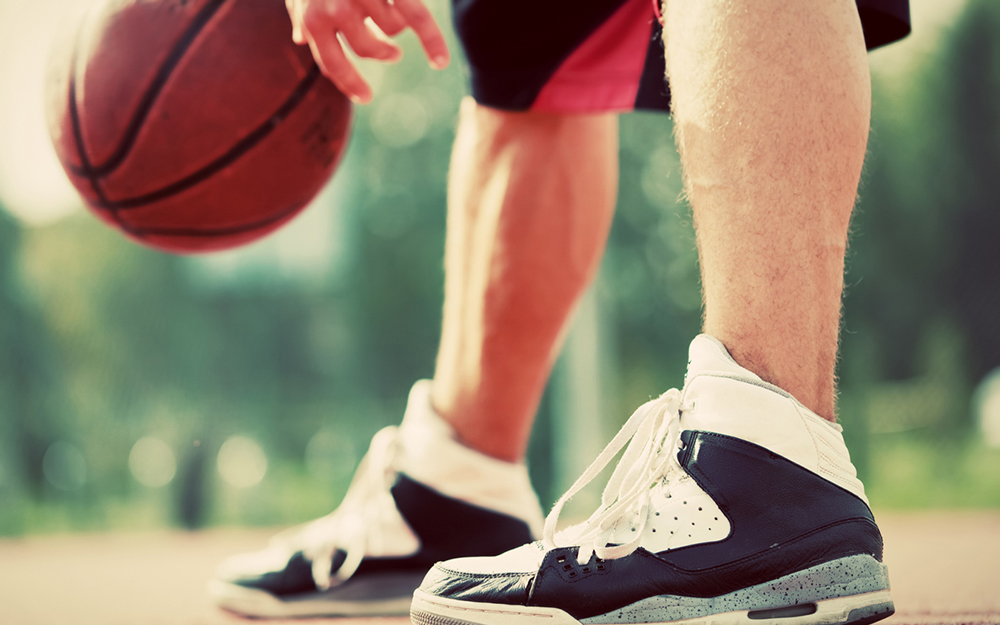 An older man playing basketball trying to avoid a torn achilles tendon.