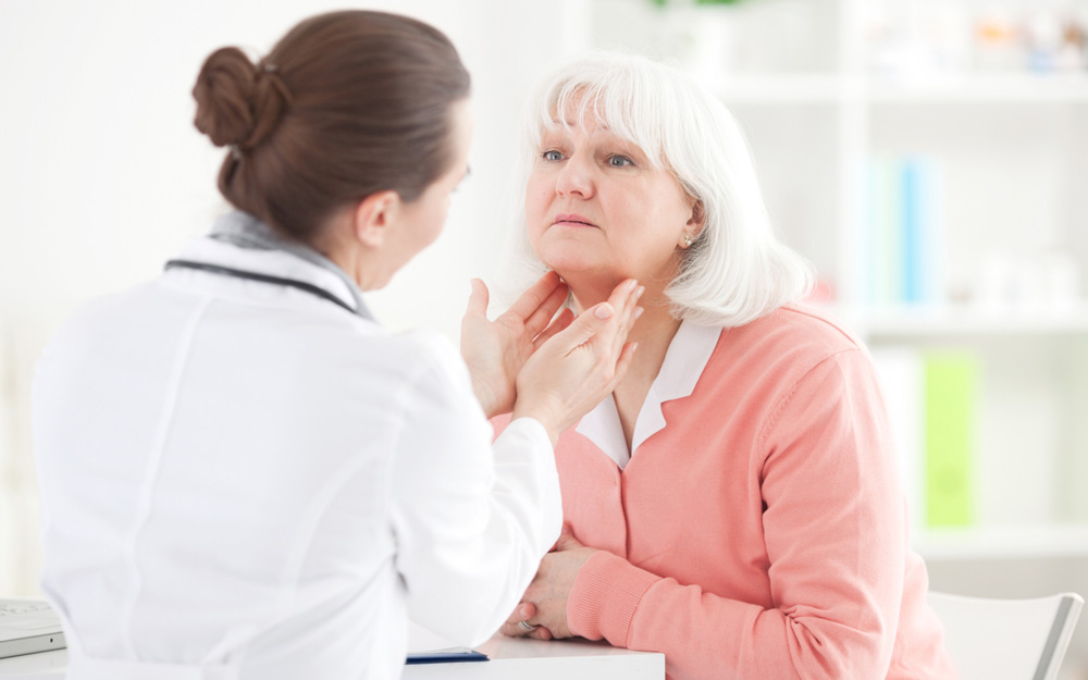 Elderly woman getting her neck examined by a doctor.