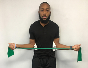 Man doing bilateral shoulder external rotations with a band.