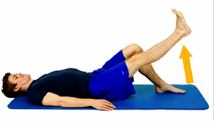Man lying on his back raising his leg.