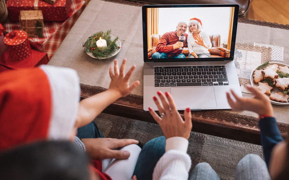 A family navigating the Holidays during the COVID-19 pandemic on a zoom call with older relatives.