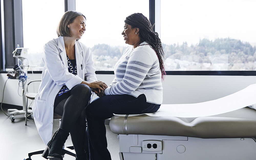 Female doctor talking to woman in hospital.