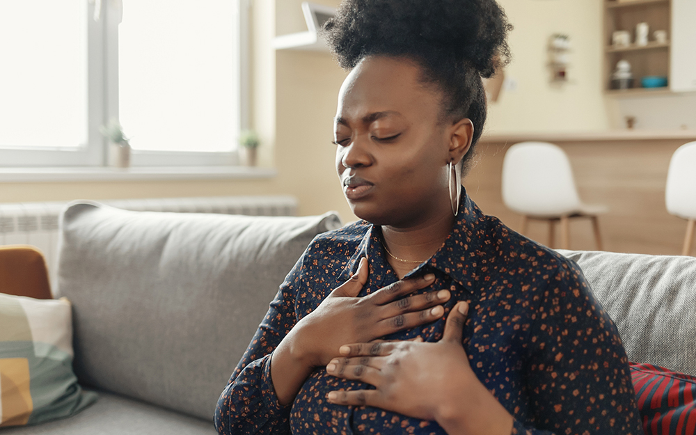 Stressed woman holding her chest area in pain.