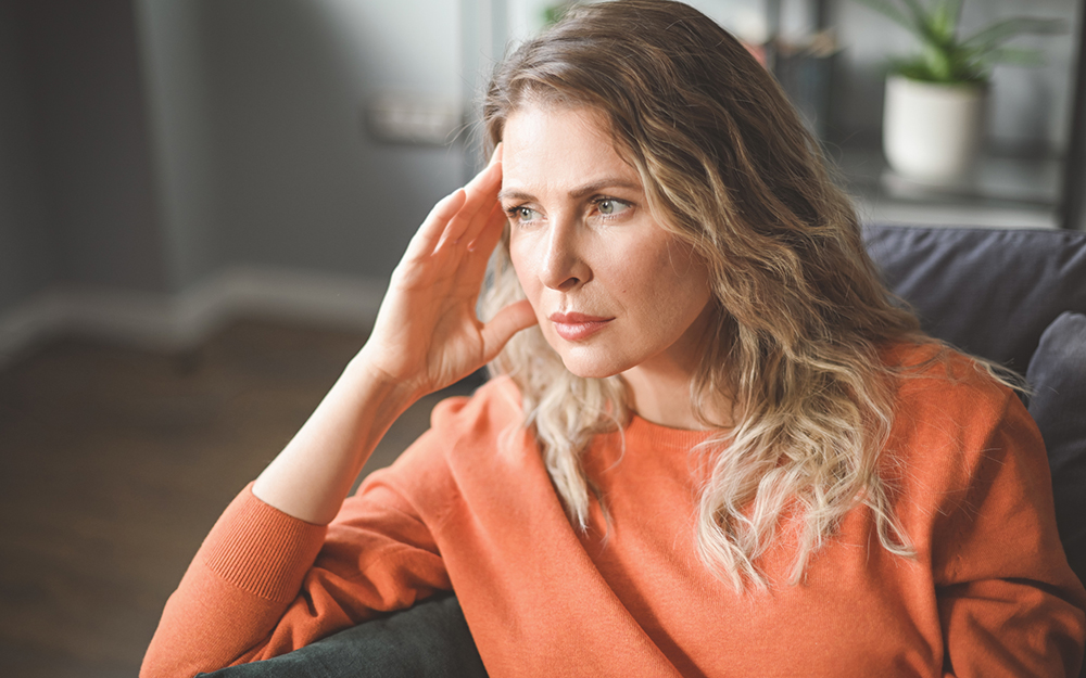Mature woman resting hand on head